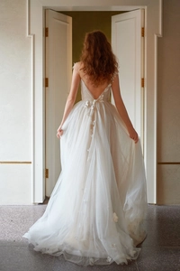 Détail du dos en V de la robe de mariée avec papillons 3D et jupe en tulle multicouche