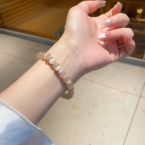 Detail of beaded chalcedony bracelet with champagne cat eye stones and silver butterfly