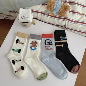 Detailed view of four cotton crew socks featuring cute cartoon dog and floral patterns