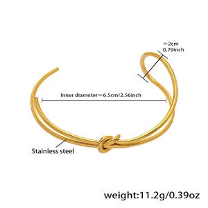 Detail van een gouden knooparmband van roestvrij staal met 6,5cm binnendiameter