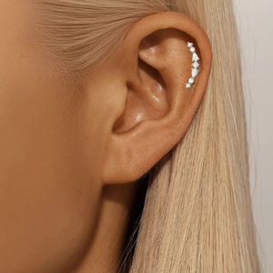 Macro detail of S925 silver ear cuff with geometric zircon stones on female ear