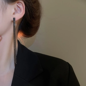 Nahaufnahme eleganter doppelreihiger schwarzer Strass-Ohrringe getragen von einem Modell