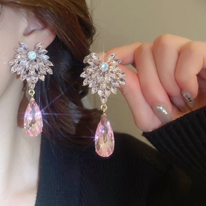 Vue macro de boucles d'oreilles pendantes avec cristal rose et grappe de zircons