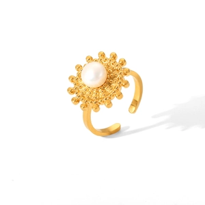 Macro view of gold stainless steel sunray ring with central white pearl inlay