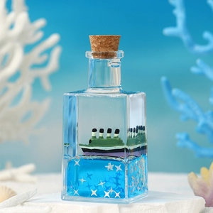 Creative liquid drift bottle decoration with miniature ship and blue fluid for desktop
