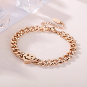 Vue détaillée du bracelet gourmette en acier inoxydable or rose avec breloque cœur smiley