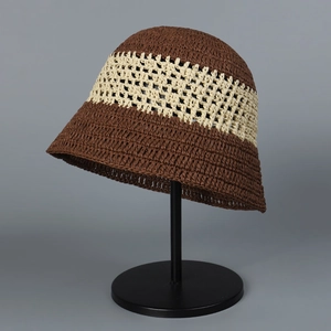 Close-up of hand-woven straw bucket hat featuring hollow crochet lace and contrast bands