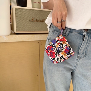 Detail of floral mini storage bag with colorful flower pattern and purple braided lanyard