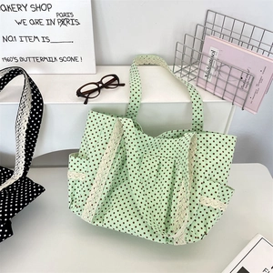 Detail of polka dot canvas tote bag featuring delicate lace trim and spacious side pocket