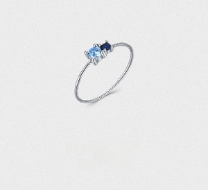 Macro detail of S925 sterling silver twisted ring with two blue round gemstones