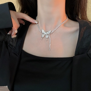 Detail of silver butterfly pendant with sparkling rhinestones and elegant tassels