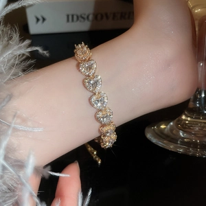 Macro shot of gold-plated heart-shaped bracelet links fully paved with pink zircon