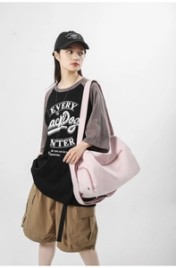 Grand sac de sport rose en nylon porté par un mannequin dans un studio professionnel