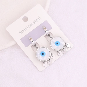 Detail of silver stainless steel long tassel earrings with evil eye heart pendant