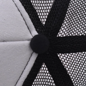 Macro detail of the top button and black breathable mesh of a western baseball cap.