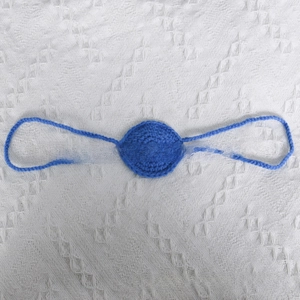 Macro detail of blue handcrafted crochet eye mask with intricate knitted texture