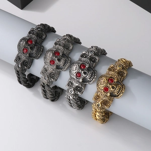 Detailed display of vintage skull bracelets with red ruby eyes in four metallic finishes