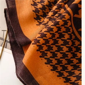 Macro detail of houndstooth scarf showing soft texture and orange-brown woven fabric