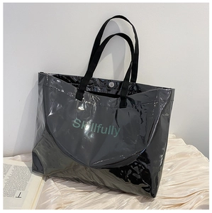 Detail view of large black PVC jelly tote bag with Skillfully print and fabric handles