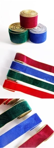 Detail of velvet Christmas ribbons with metallic edges in red, blue, and green colors