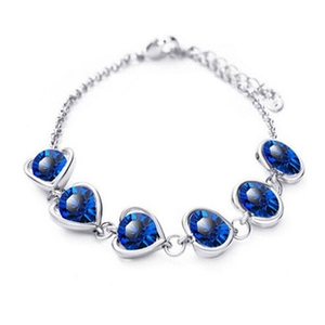 Detail of sapphire blue heart-shaped faceted crystals on silver metal chain bracelet