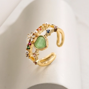 Adjustable gold open ring with green heart stone, white flower, and colorful crystals