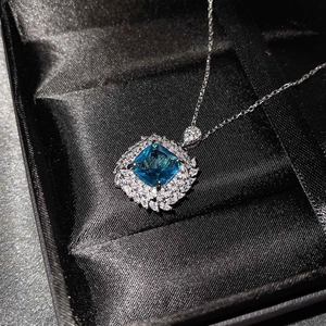 Close-up of a square blue gemstone pendant with diamonds in a black jewelry box