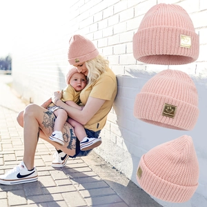 Pink knitted beanie with cute smiley face metal plate for parents and children