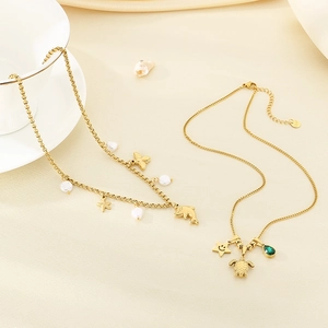 Gold ocean themed necklace with starfish seashell pendants and pearls on beige cloth