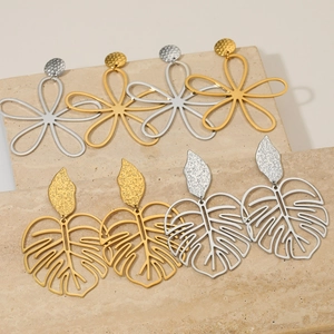 Ensemble de boucles d'oreilles trèfle et feuille en acier or et argent sur pierre