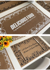 Close-up of rectangular woven placemat with elegant floral prints and text on a white table