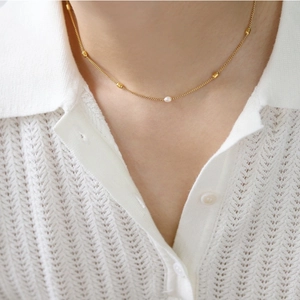18K gold plated necklace with tiny beads and a natural pearl shown on a model