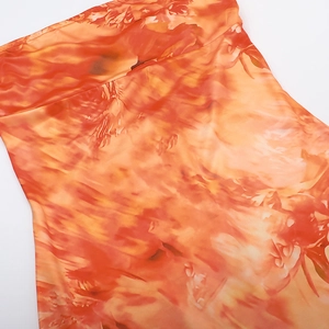 Detail of vibrant orange and yellow abstract floral print on a slim fit strapless dress