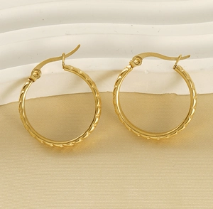 Close-up of 18K gold-plated stainless steel hoop earrings with woven texture detail