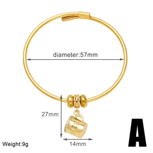 Detalle de pulsera dorada con cuentas caladas y colgante de taza de café con circones