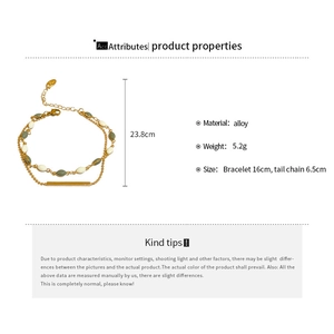 Detail view of double-layered gold plated bracelet with green beads and bar pendant