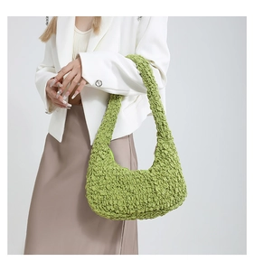 Macro detail of vibrant green bubble pleated texture on large crescent hobo bag