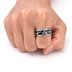 Close-up of a rotating silver and black Freemason ring on a male finger in punk style