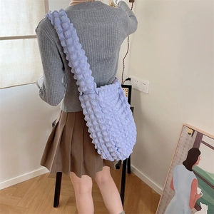 Detail of purple popcorn fabric shoulder bag showing textured material and slouchy fit