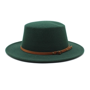 Détail du chapeau en laine vert foncé avec bord plat et ceinture en cuir marron bouclée