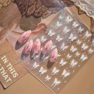 White butterfly nail stickers set with pink gradient press-on nails on vintage paper