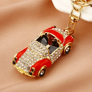 Close-up of red vintage car keychain with sparkling rhinestones and golden metal ring