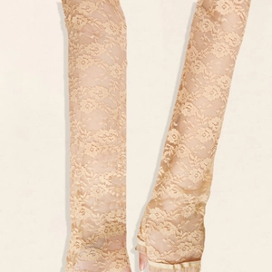 Close-up of elegant champagne floral lace texture on long fingerless sun protection gloves
