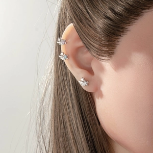 Star and comet ear piercings in silver finish with colorful crystals on female ear