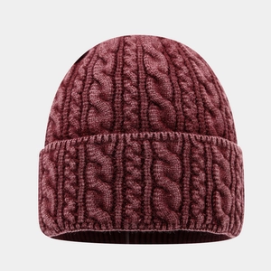 Détail de la maille torsadée et du revers côtelé sur un bonnet d'hiver bordeaux épais