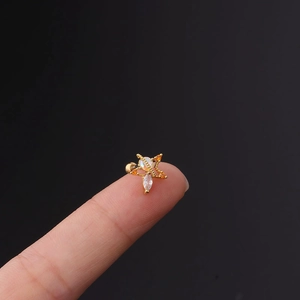 Detail of star-shaped 20G stainless steel stud with colorful cubic zirconia held on a fingertip