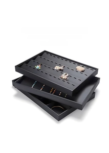 Macro view of modular black jewelry organizer tray with velvet hooks and compartments