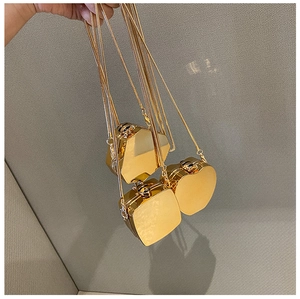 Detailed view of three mini gold mirror metal bags in apple, hexagon, and square shapes