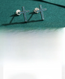 Macro shot of 925 sterling silver cross studs with turquoise inlay and S925 hallmark