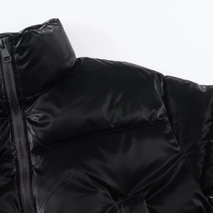 Detail of high-gloss water-resistant fabric and stitching on black shiny puffer jacket